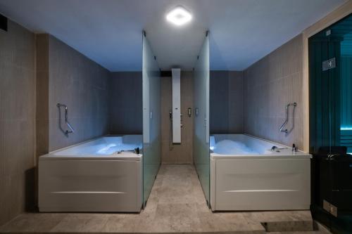 普里什蒂纳Emery Hotel的一间带两个浴缸和淋浴的浴室