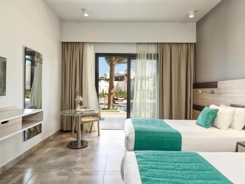赫尔格达Ancient Sands Golf Resort and Residences的酒店客房设有两张床和庭院。