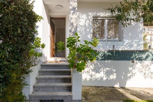卡帕里卡海岸Villas Boas House Caparica的白色的房子,设有楼梯和窗户