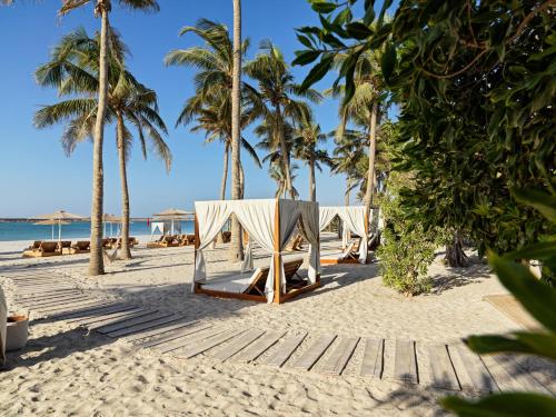 塞拉莱法纳尔酒店及公寓的棕榈树海滩上的一排帐篷