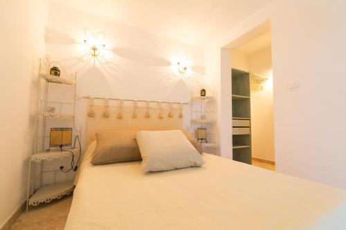 圣弗洛朗Appartement T2 rez de villa的卧室配有一张带两盏灯的墙壁床。