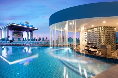 阿萨拉尔Granada Luxury Beach-Ultra All Inclusive的大楼前的酒店游泳池