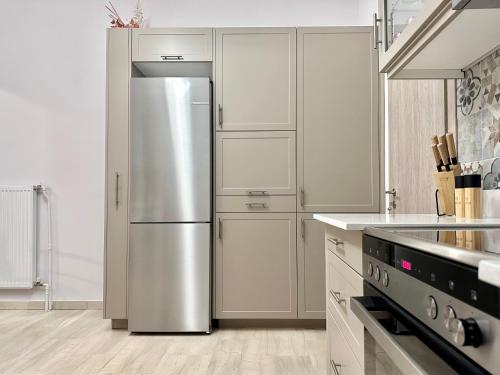 雅典Elaia Luxury Selections Sapphire的一间厨房内的不锈钢冰箱,厨房内有白色的橱柜