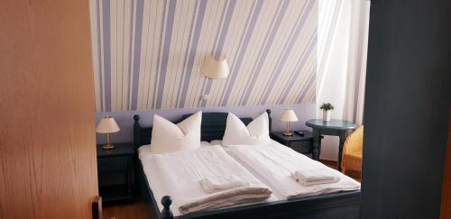 维滕贝克Restaurant und Pension Zur Nassen Ecke的一间卧室配有带白色床单和枕头的床。