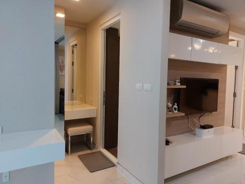MakkasanCondominium Sukhumvit Soi 5 - BTS Nana- Room Size 47m2的客厅配有电视和白色墙壁。