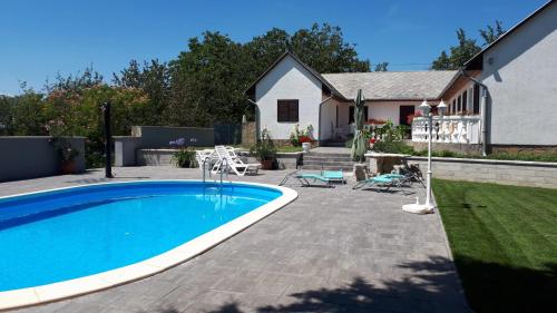 沃尼奥尔茨沃什海吉Főnix Apartmanház的一个带游泳池和房子的后院