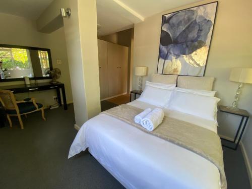 贝尔维尔Vredelust Cottage的一间卧室配有一张大床和两条毛巾