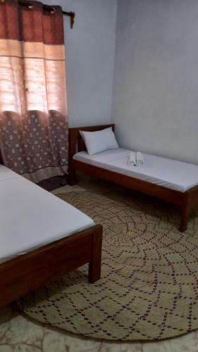 拉穆JAHA的两张床铺位于带地毯的房间