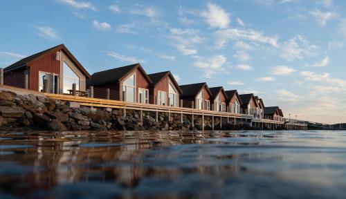 布伦讷于松Norsk Havbrukssenter - Rorbuer的水边码头上的一排房子