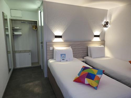 瓦尔瑟里恩河畔贝勒加尔德奇利亚贝尔嘉德酒店 - 日内瓦的配有色彩缤纷枕头的小客房内的两张床