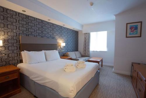 布雷得佛Tong Park Hotel的酒店客房,配有带两条毛巾的床