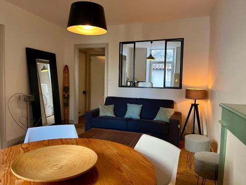 拉罗谢尔Dormir À La Rochelle 1 avec Parking的客厅配有桌子和蓝色沙发