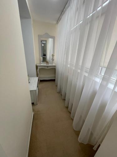 GiurgiuApartament 2 camere ultracentral的走廊上设有白色窗帘和水槽