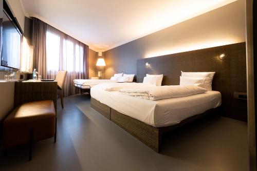 泰尔托GINN Hotel Berlin Potsdam的酒店客房配有两张床和一张书桌