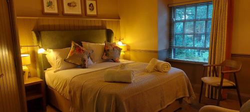 科尼斯顿皇冠客栈的一间卧室配有一张床,上面有两条毛巾