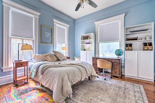 小石城Historic Home Near Downtown Little Rock!的一间卧室设有蓝色的墙壁、一张床和一张书桌