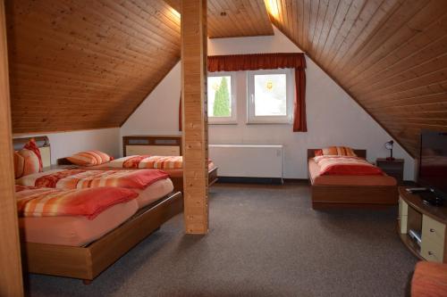 奥尔斯贝格菲利恩豪斯梅德巴赫酒店的阁楼卧室设有两张床和窗户。