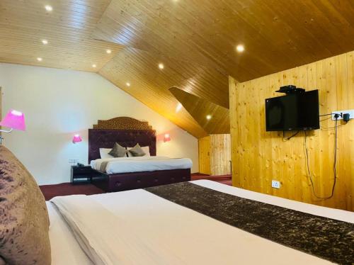 马拉里Hotel Hadimba palace的一间卧室配有一张床和一台平面电视