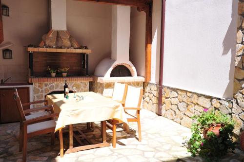 阿莫利亚尼岛Pansion Evi的天井配有桌椅和比萨饼烤箱