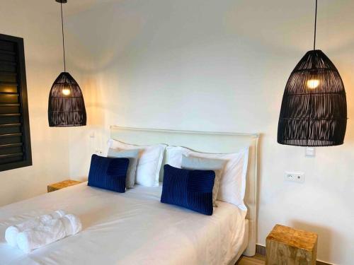 勒马兰CASA FERDI 1, logement entier avec piscine privée的一间卧室配有白色的床和2个蓝色枕头