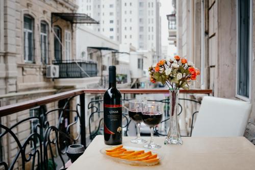 巴库City Inn Nizami Boutique Hotel的阳台上的桌子上放有一瓶葡萄酒和玻璃杯