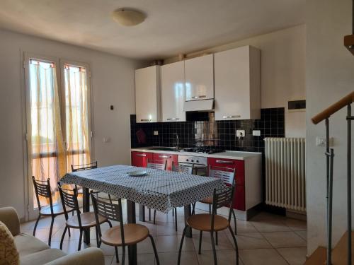 切齐纳码头Giacomo Home的一间带桌椅的厨房和一间带白色橱柜的厨房