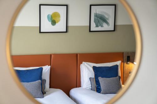 爱丁堡voco Edinburgh - Royal Terrace, an IHG Hotel的镜子反射着酒店客房内的两张床