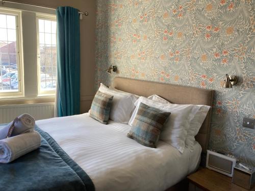 惠特比惠特比车站宾馆的一间卧室配有带白色床单和枕头的床。