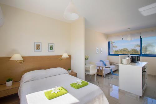 普罗塔拉斯Flouressia Gardens的酒店客房,配有一张带两张绿色毛巾的床