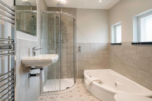 沃金厄姆Cantley House Hotel - Wokingham的带淋浴、盥洗盆和浴缸的浴室