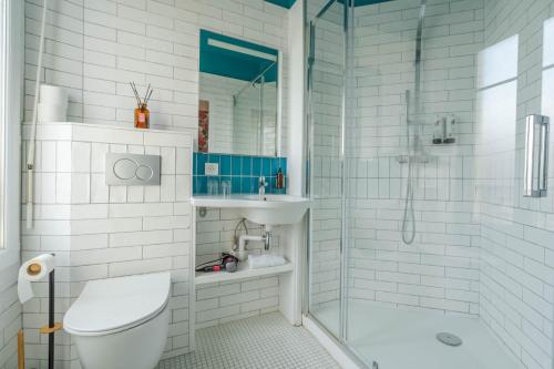 比亚里茨Ama Hôtel的带淋浴、卫生间和盥洗盆的浴室