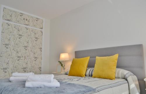 科尔多瓦SunShine Tejares Garden的一间卧室配有一张带黄色枕头的床