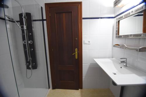 洛斯科拉莱斯-德布埃尔纳La casona de Llano的带淋浴、水槽和门的浴室
