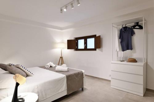 阿尔巴塔克斯Cosy and Modern Apartment Portu Frailis的白色卧室配有床、梳妆台和镜子