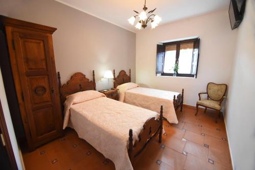 洛斯科拉莱斯-德布埃尔纳La casona de Llano的一间卧室设有两张床、一把椅子和一个窗户。