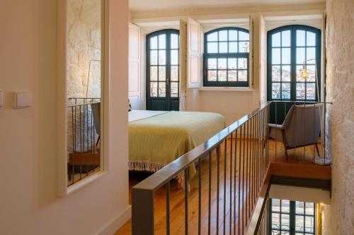 波尔图AgapeStay Porto的一间卧室设有一张床,楼梯设有窗户