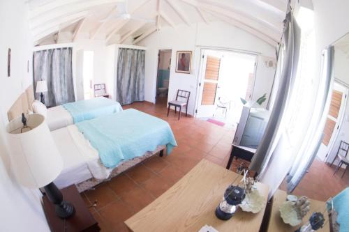 OracabessaCountry Side Cottages的一间卧室配有一张床、一张桌子和一台电视。
