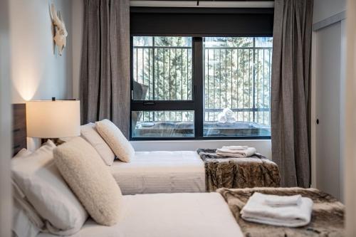 雷夫尔斯托克Peaks and Birdies by Revelstoke Vacations的一间卧室设有两张床和大窗户