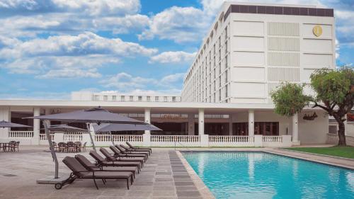 卢萨卡卢萨卡洲际酒店 的游泳池旁的酒店拥有椅子和遮阳伞
