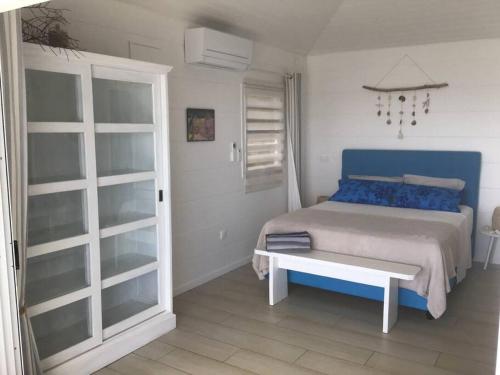 OpoaPkbleucoco的一间卧室配有一张带蓝色枕头的床和一张桌子