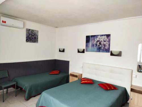 耶尔卡吕普索酒店的客房内的两张床和红色枕头