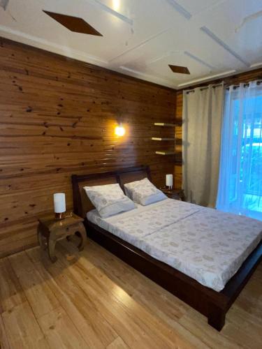 卡夫尔高原Entre Volcan et Montagnes的一间卧室设有一张床和木墙