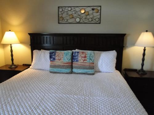鸽子谷River Crossing Resort的一间卧室配有一张带枕头的床和两盏灯。