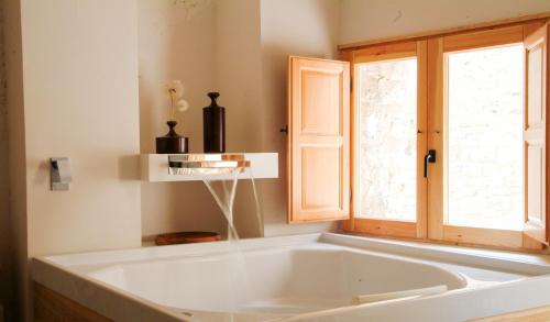TarrésClauhomes Casa Rural Deluxe的窗户客房内的白色大浴缸