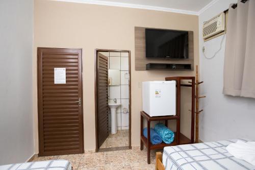 巴雷图斯Hotel Portela I -Barretos的一间小型客房,配有冰箱和电视