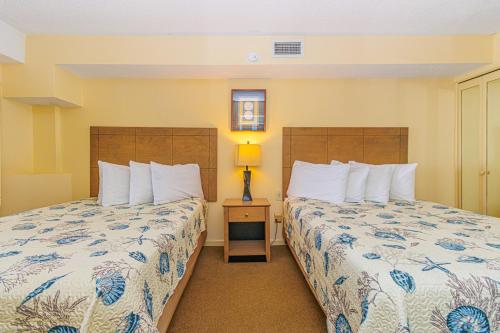 默特尔比奇Beach Colony Resort Unit 1405 - Beautiful Oceanfront Condo - 1 bedroom, 1 bath - Perfect for 6!的酒店客房,设有两张床和一盏灯