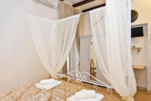 塔兰托斯巴达旅馆的一间卧室配有带窗帘和镜子的床