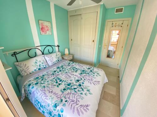 贝纳尔马德纳BED & BREAKFAST Benalmádena HABITACION EN PISO COMPARTIDO的一间卧室配有一张带紫色和蓝色床单的床。