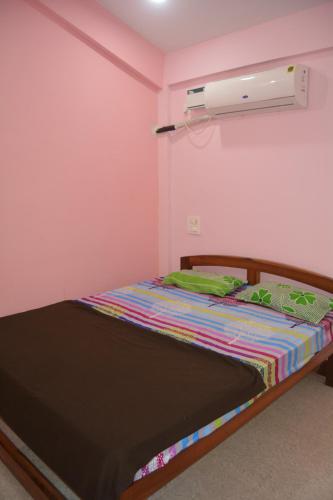 莫尔吉姆chill out home morjim的粉红色墙壁的房间里一张床位