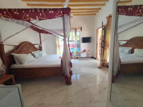 桑给巴尔BARIDI VILLA的一间卧室配有两张床和镜子